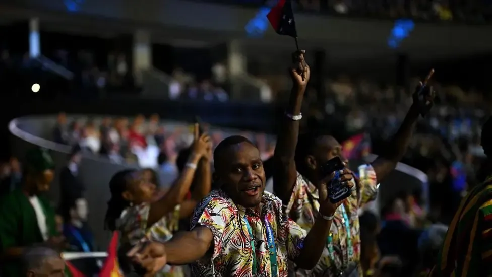 Athletes in colourful outfits dance during opening ceremony