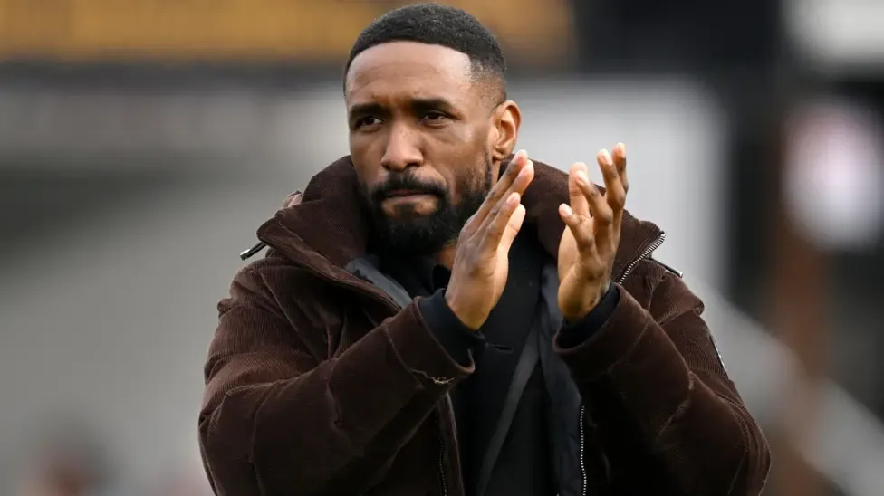 Jermain Defoe, in a brown cord jacket, applauds fans after the National League match between Woking and Eastleigh last season