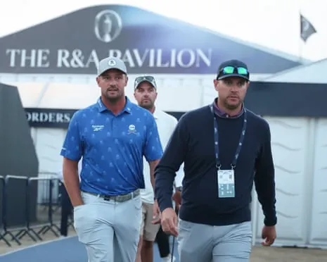Bryson DeChambeau (left) and his agent Brett Falkoff head for Birkdale’s driving range after the American received a two-shot penalty.