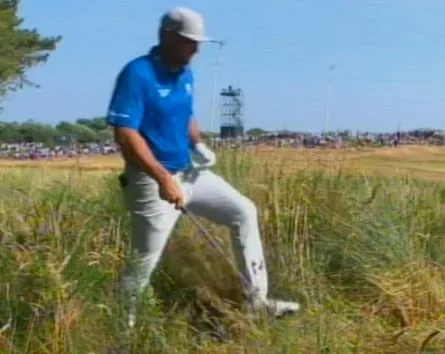 Bryson DeChambeau walks in the long grass where his ball lies in the rough on the 5th hole.