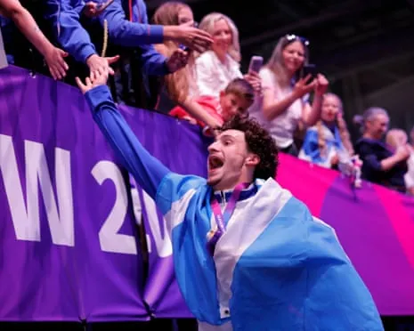 Reuben Ward celebrates with fans after winning the men's all-around final in artistic gymnastics at the Commonwealth Games.