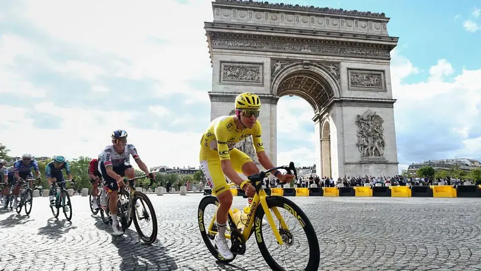 Tadej Pogacar rides past the Arc de Triomphe