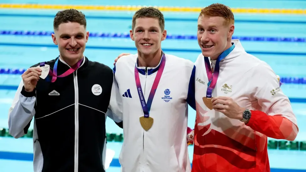 Scotland's Duncan Scott and England's Tom Dean join New Zealand's Lewis Clareburt to pose with their Commonwealth Games medals