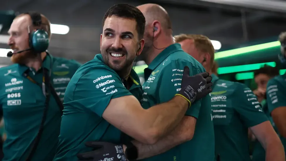 Aston Martin team members celebrate Fernando Alonso's progress into Q2